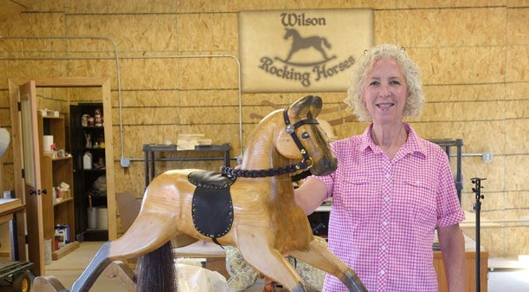 A Luther craftswoman constructs rocking horses by hand