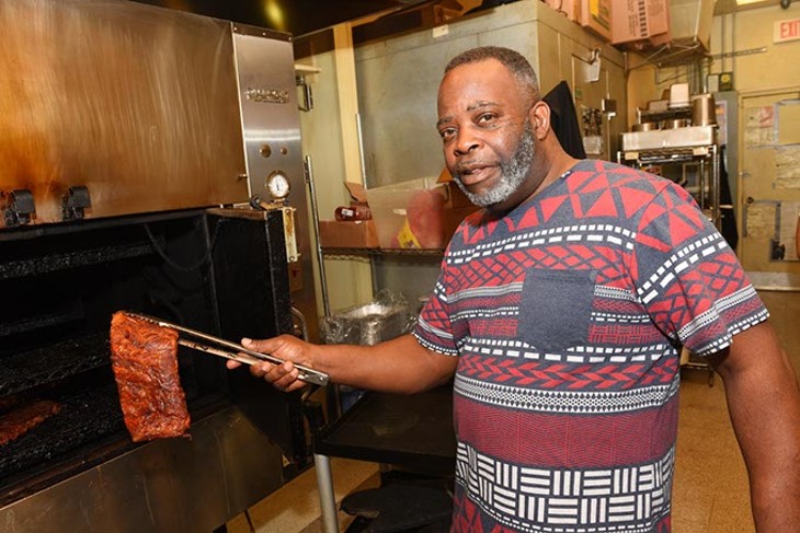 Marvin Preston pulls ribs out of the smoker at Dickey&#146;s Barbecue Pit, a franchise he took over after nearly three decades out of the restaurant business.(Garett Fisbeck)